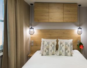 a bedroom with a bed with two lights above it at Club del Sole Rimini Family Resort in Rimini