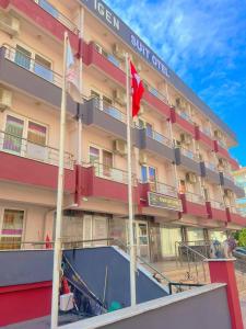 un hotel con banderas frente a un edificio en Figen Suite Hotel 2 en Çanakkale