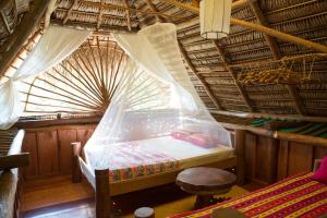 a bedroom with a bed with a canopy over it at El Hotelito Perdido in Río Dulce