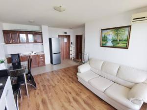 a living room with a white couch and a kitchen at Milana-2 Sea View in Byala