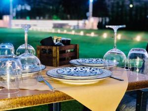 Marigianna Apartments في سيسي: طاولة عليها صحون واكواب للنبيذ