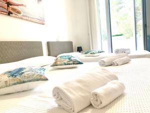 un paio di letti con sopra asciugamani di Villa Azzuro Blue a Lignano Sabbiadoro