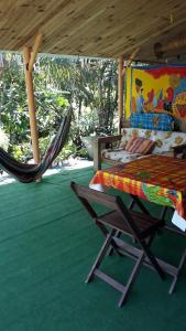 d'un hamac, d'un lit, d'une table et d'une chaise. dans l'établissement Le gîte du pêcheur, à La Trinité