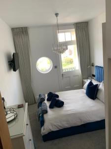 um quarto com uma cama com almofadas azuis em Lazy Waves Boutique B&B em Newquay