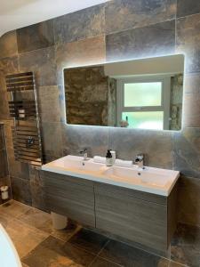 a bathroom with a sink and a mirror at Modern studio apartment with stunning views! in St Ives
