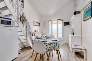 Una cocina y un comedor con mesa y sillas. en Face mer - Trou du Diable sur la Corniche, en Les Bussolleries