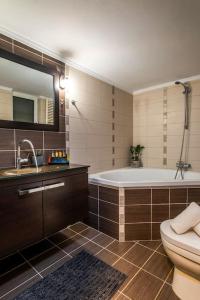 łazienka z wanną, toaletą i umywalką w obiekcie Emma Hills Villa w mieście Korakiaí