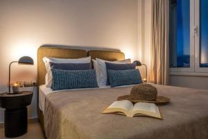 uma cama com um livro e um chapéu em Emma Hills Villa em Korakiaí