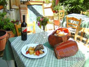 una mesa con una botella de vino y un plato de comida en Manoleas Rooms to Let, en Leonidio