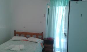 a bedroom with a bed with two towels on it at Manoleas Tavern & Rooms to Let in Leonidio