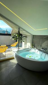 Alfea Deluxe Loft & Rooms في ترينتو: حوض استحمام كبير في غرفة مع فناء