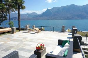 a patio with a view of the water and mountains at Beach Villa Fiorina in Ghiffa