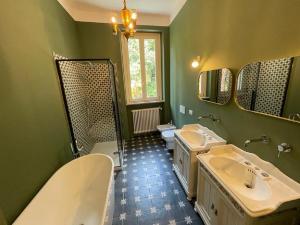 a green bathroom with two sinks and two mirrors at Beach Villa Fiorina in Ghiffa +46 photos