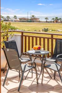 a table and chairs on a balcony with a view of a field at Villa Rosedale by Ezoria Villas in Ayia Napa