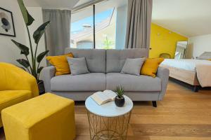 a living room with a couch and a bed at Alfea Deluxe Loft & Rooms in Trento