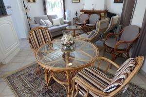 sala de estar con mesa de cristal y sillas en Villa Xoriguer, en Denia
