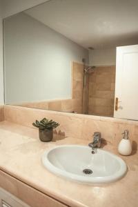 La salle de bains est pourvue d'un lavabo et d'un miroir. dans l'établissement Los Piños, 2 Bedroom Apartment with panoramic view, à Benahavís