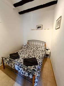 ein Schlafzimmer mit einem Bett in einem weißen Zimmer in der Unterkunft Casa en la Valleta in Ginestar