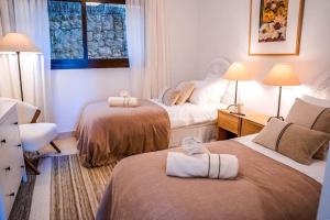 pokój hotelowy z dwoma łóżkami i ręcznikami na nich w obiekcie Los Piños, 2 Bedroom Apartment with panoramic view w mieście Benahavís +37 zdjęć