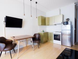 a kitchen with a table and chairs and a refrigerator at Central City Apartments in Oslo