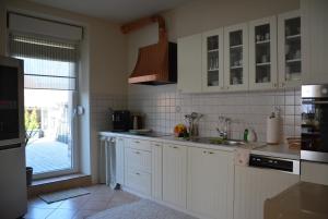 Una cocina con gabinetes blancos y una ventana grande. en Ferienhaus Waldorf, en Biebelsheim