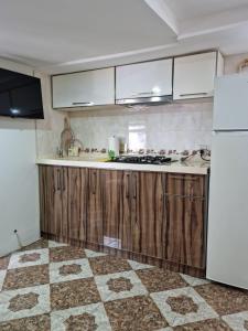 a kitchen with wooden cabinets and a white refrigerator at тихий дворик in Baku
