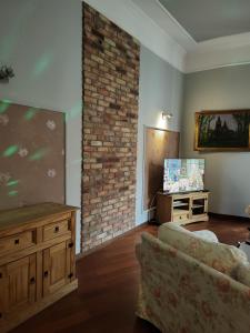 salon z kanapą i ceglaną ścianą w obiekcie Charlotte Apartment w Tarnowie