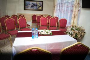 a conference room with a table and red chairs at THE PLANTAINS PLACE in Karatina