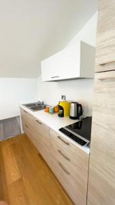 Alfea Deluxe Loft & Rooms في ترينتو: مطبخ مع مغسلة وموقد فرن علوي