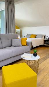 Alfea Deluxe Loft & Rooms في ترينتو: غرفة معيشة مع أريكة وسرير