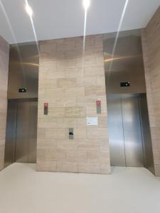 Un gran muro de piedra en un edificio con dos ascensores. en Old City Apartment, en Tiflis