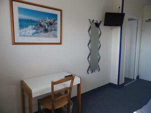a room with a desk and a tie hanging on a wall at Hôtel du Petit Matelot in Saint-Pierre-Quiberon