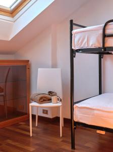 een slaapkamer met een stapelbed en een tafel met een stoel bij APPARTAMENTO GHITA in Baveno