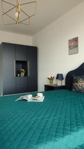 a room with a green carpeted floor and a room with a table at Apartament Szmaragdowy Light Tower Aquapark Reda in Reda