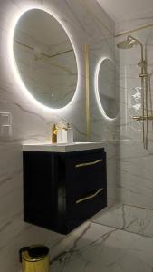 a bathroom with a sink and a mirror at Apartament Szmaragdowy Light Tower Aquapark Reda in Reda