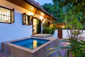 a swimming pool in the backyard of a house at Thai Style 2BR Villa Nikkie 2 in Nai Harn Beach