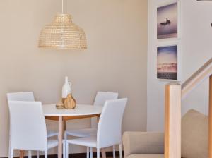 a dining room with a white table and white chairs at APPARTAMENTO GHITA in Baveno