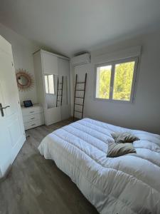 a white bedroom with a large bed and a window at maison 6 personnes villa sofia in Sainte-Maxime