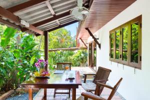 a dining room with a table and chairs on a patio at Thai Style 2BR Villa in Nai Harn Beach