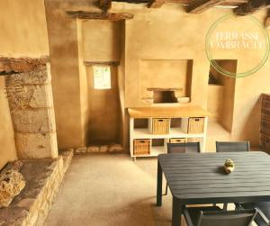 a kitchen with a table and a stove in a room at L'authentique Martelaise PISCINE CHAUFFEE in Martel