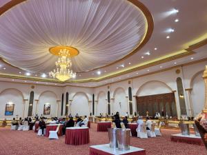 a large banquet hall with people sitting at tables at Ratna Vilas Palace in Rajkot