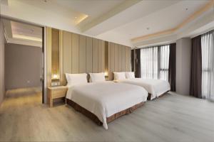 a hotel room with two beds and a large window at Gamalan Star Hotel in Jiaoxi
