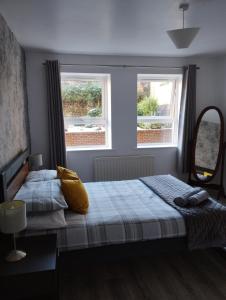 a bedroom with two beds and two windows at Donard Holidays in Newcastle