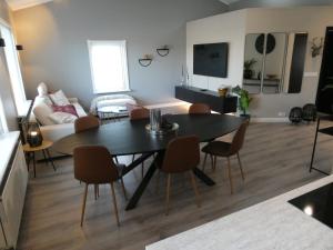 - un salon avec une table, des chaises et un canapé dans l'établissement Northberg Apartments, à Keflavík