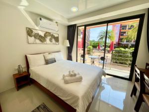 Un dormitorio con una cama con un osito de peluche. en 777 Beach condo - family condo near Mai Khao beach en Ban Mai Salae