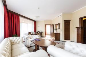 uma sala de estar com mobiliário branco e uma mesa em Hotel Crocus em Zakopane