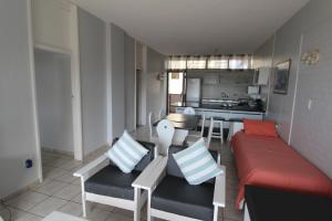 uma sala de estar com um sofá e cadeiras e uma cozinha em Seagull 305 em Margate