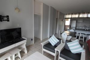 uma sala de estar com um sofá e cadeiras e uma cozinha em Seagull 305 em Margate