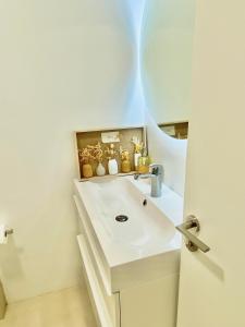 W łazience znajduje się biała umywalka i lustro. w obiekcie Barcelona Chic Apartments- Free Parking-10 min by metro from BCN Center w Barcelonie