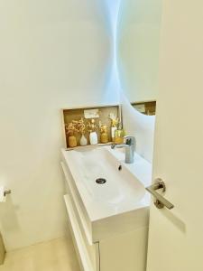 un bagno con un lavandino bianco e uno specchio di Barcelona Chic Apartments- Free PARKING - 10 min from BCN city centre by metro a Barcellona Altre 37 foto